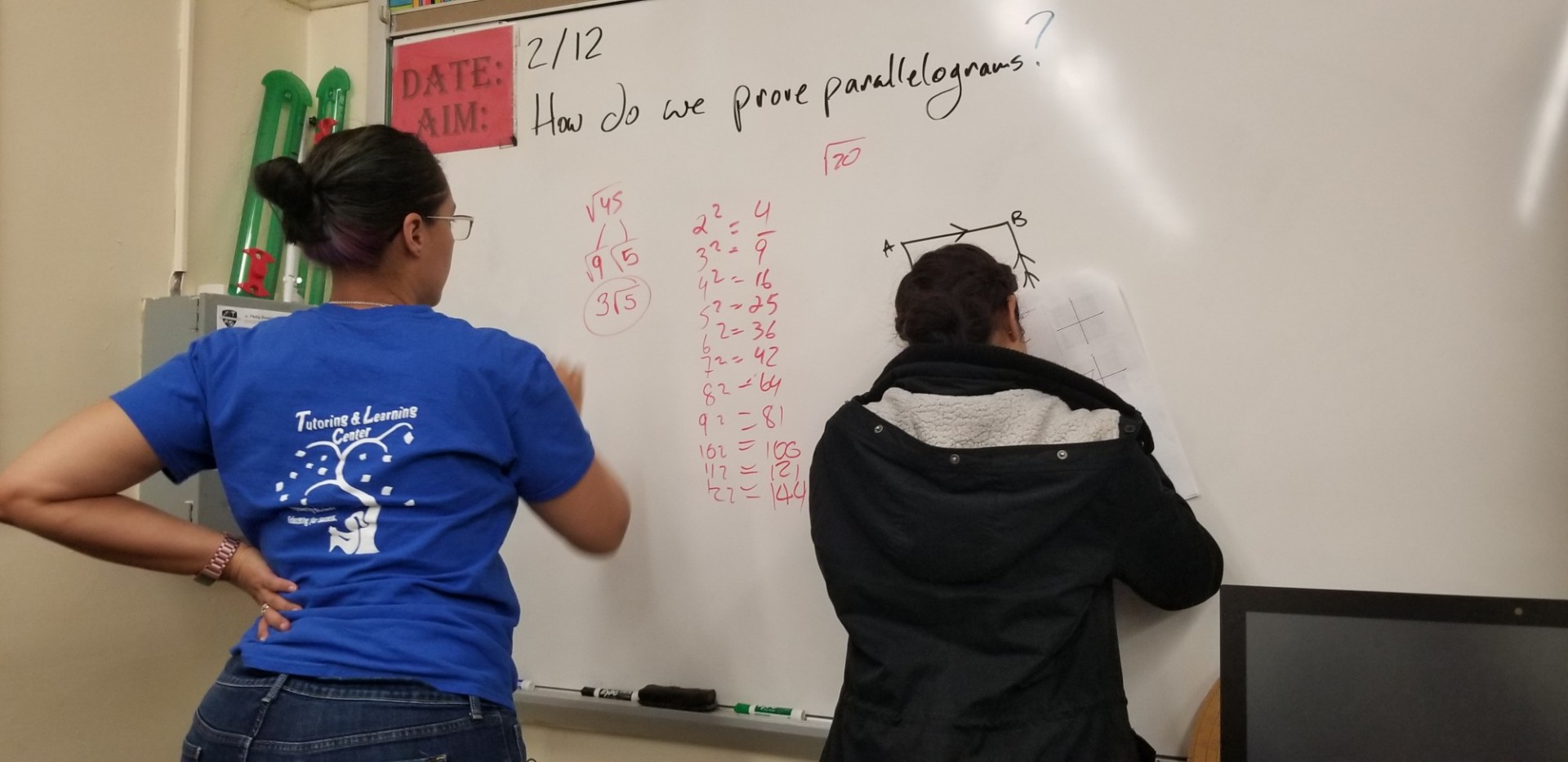 Tutors writing on whiteboard