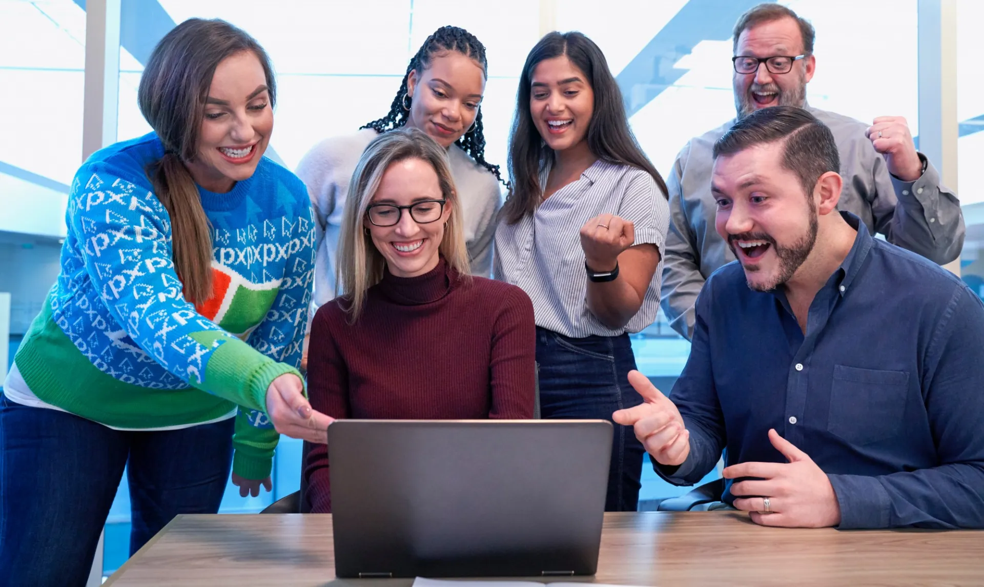 A group of people cheering onto the computer